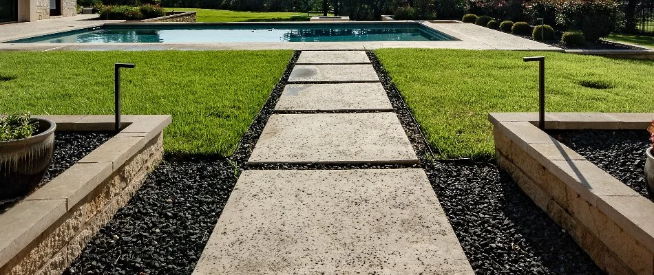 Outdoor space in Texas with walkway, pool, and grass.