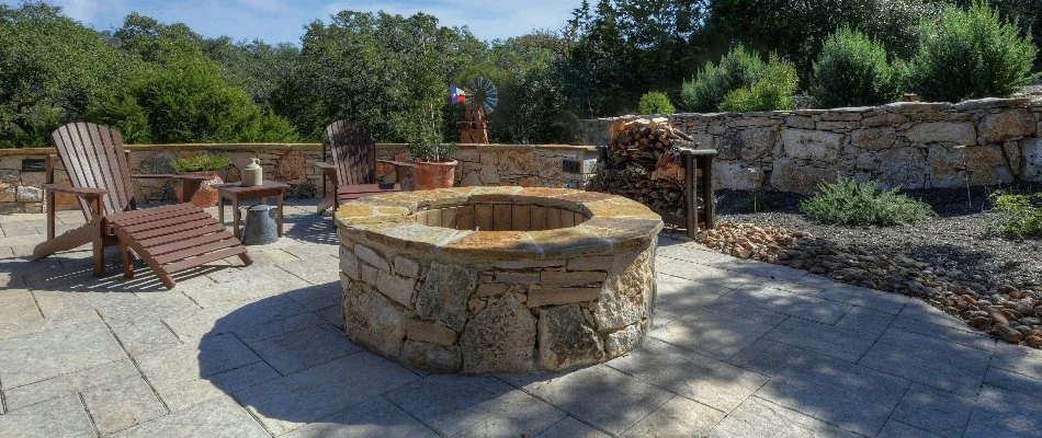 Stone fire pit on a patio in Hunter, TX, with surrounding landscaping.
